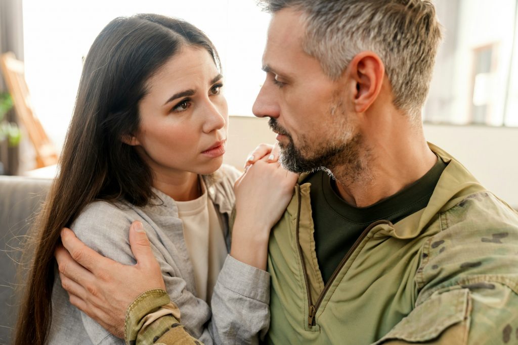 Sad young military soldier saying goodbye to sad wife