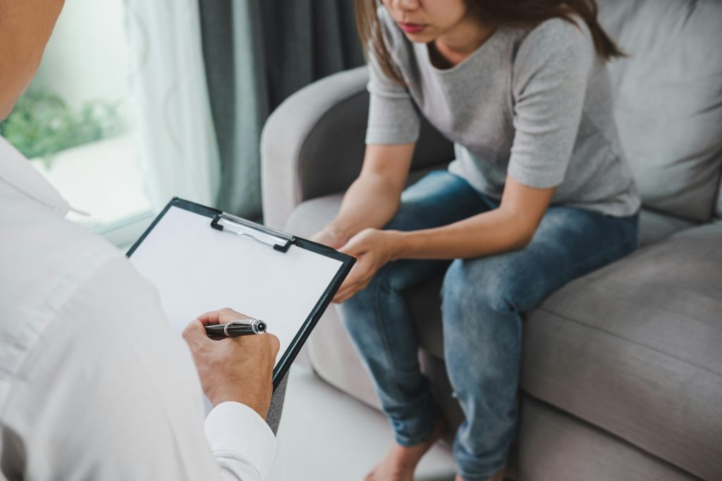 doctor filling medical patient information consulting his depressed patient